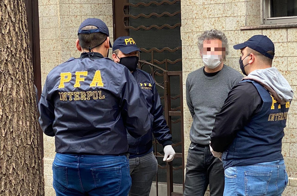 Agentes de la Policía Federal Argentina y de la OCN de INTERPOL en Buenos Aires detienen a una persona.