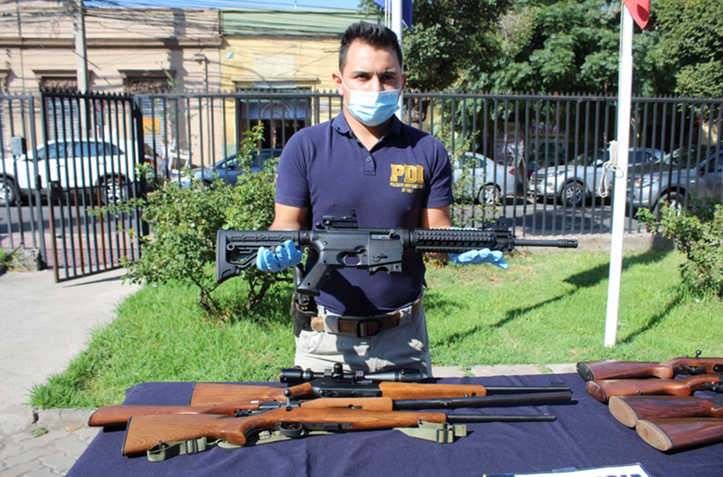 Chilean officers showcase illegal weapons seized during Operation Trigger VI where some 200,000 illicit firearms, parts, components, ammunition and explosives across South America were recovered